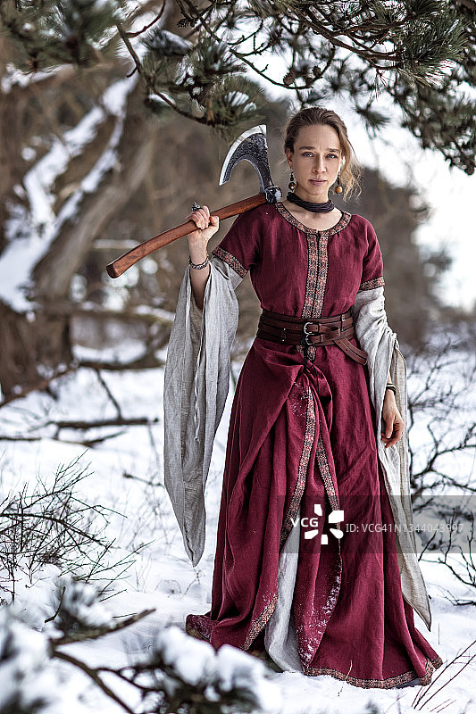 在白雪皑皑的森林里美丽的金色维京女战士公主图片素材