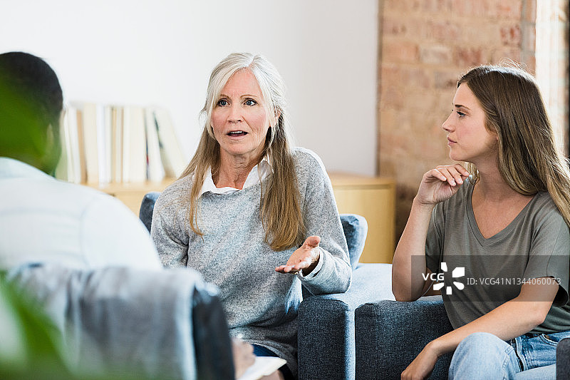 在治疗师和女儿的注视下，女人用手势自卫图片素材