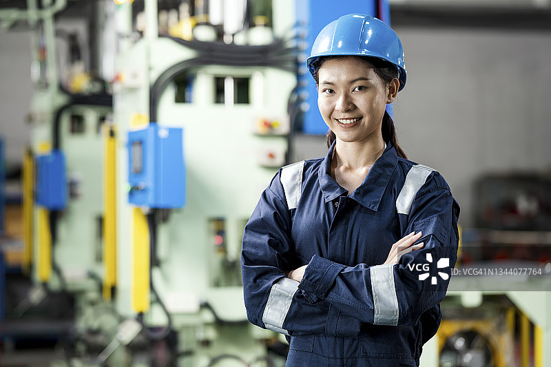 构建预测性维护系统：女工业工程师站在自动化机械压力机前图片素材