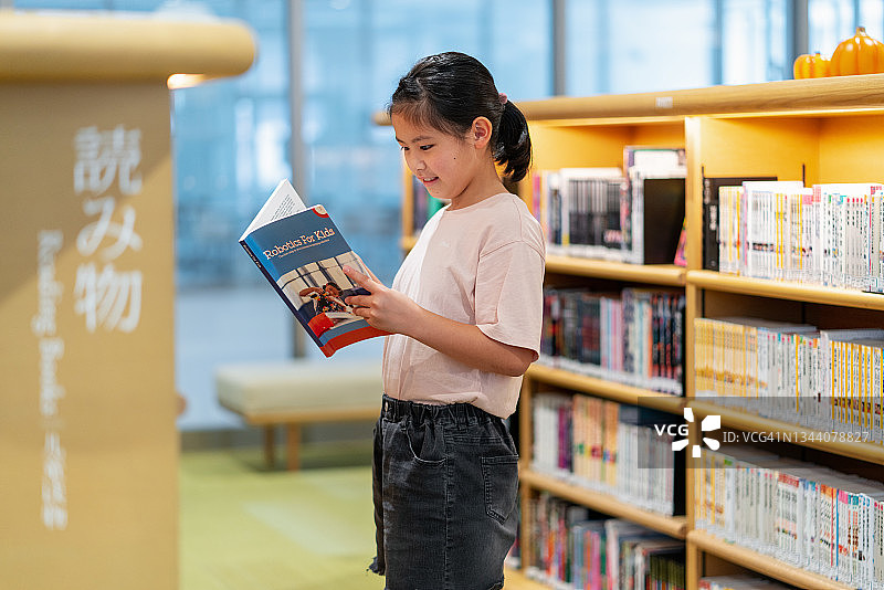 年轻女孩在图书馆里读书图片素材