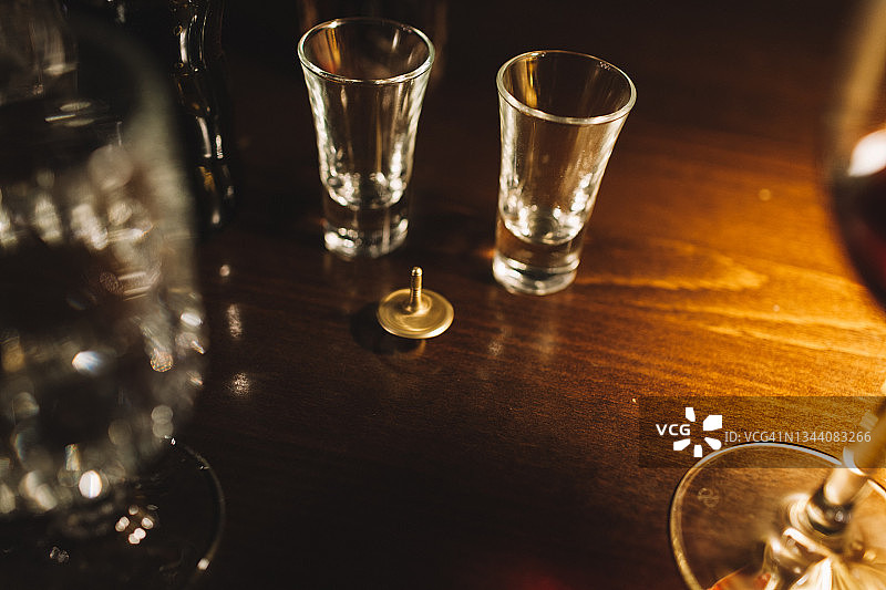 暖光下木桌上的玻璃杯和旋转玩具特写图片素材
