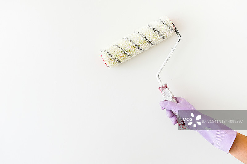 油漆工手中的白色油漆滚筒图片素材