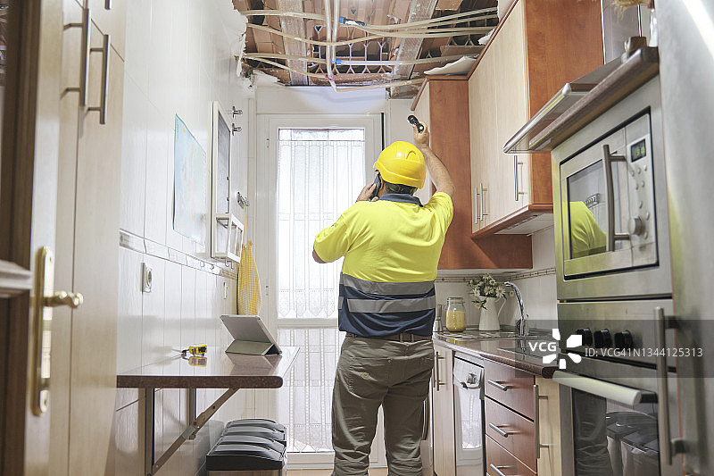 水管工评估管道破裂造成的损坏和漏水图片素材