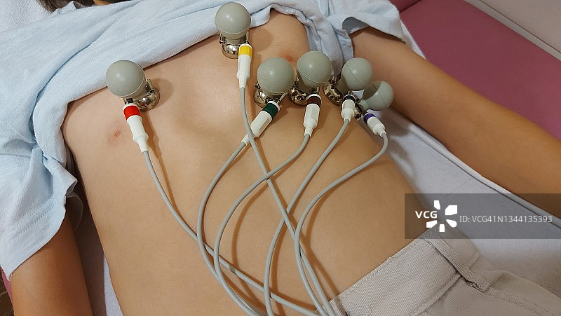 男孩躺在诊所床上接受心电图检查的特写图片素材