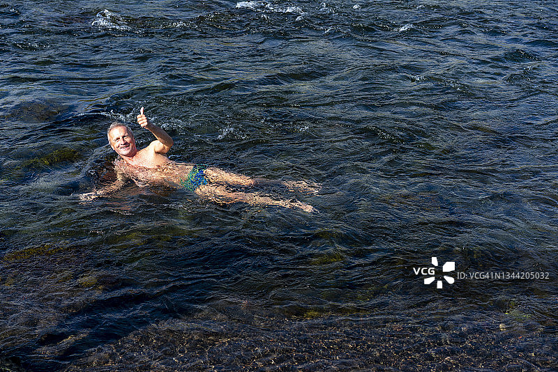 男人在冰岛北部Fosslaug温泉浴后享受清凉图片素材