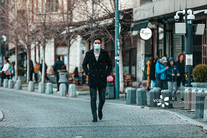 男人戴着外科绷带，背景是现代建筑，关于疫情图片素材