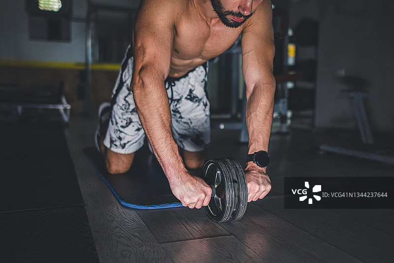 男子用健腹轮锻炼腹肌图片素材