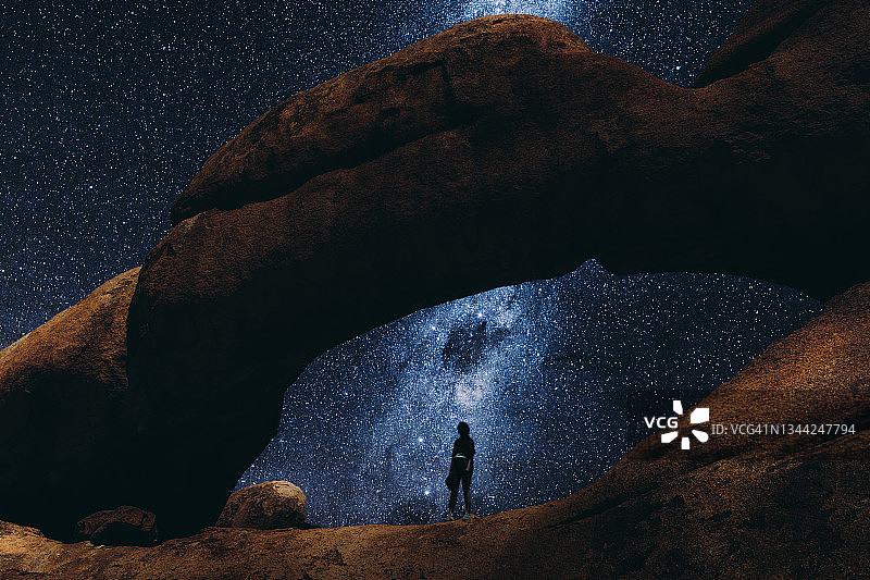 女人在纳米比亚的天然拱门内仰望星空图片素材