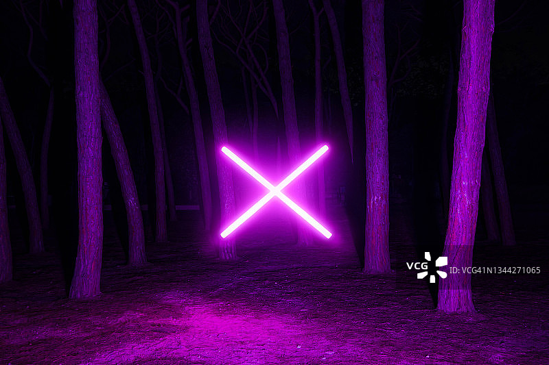 夜晚黑暗森林中悬浮的未来主义霓虹灯十字架图片素材