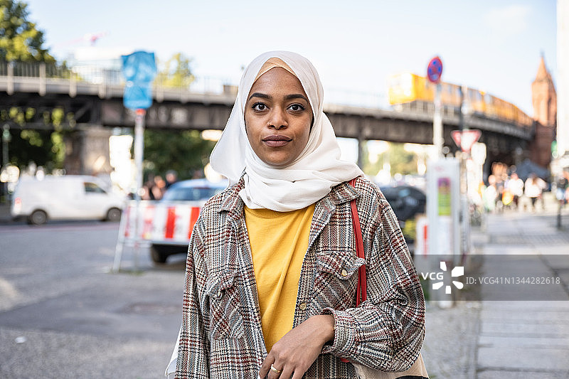 在柏林上树桥前的戴着头巾的年轻女子肖像图片素材