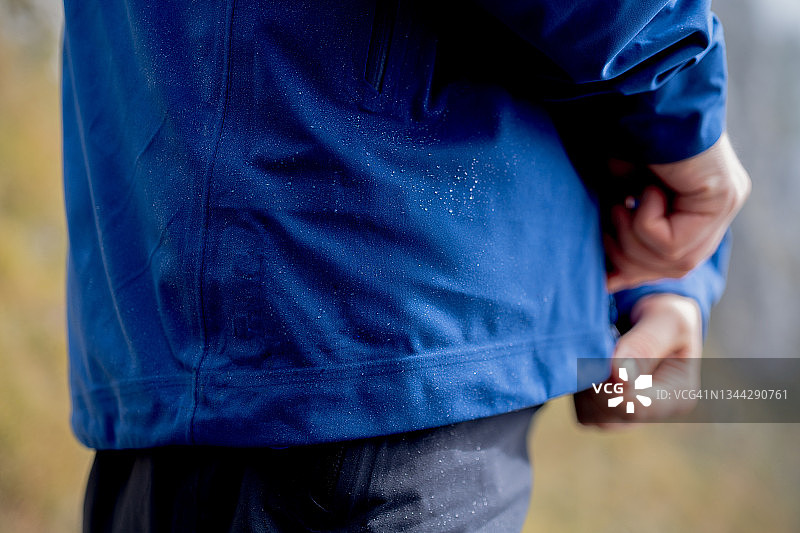 男人拉上雨衣拉链，雾气袭来图片素材