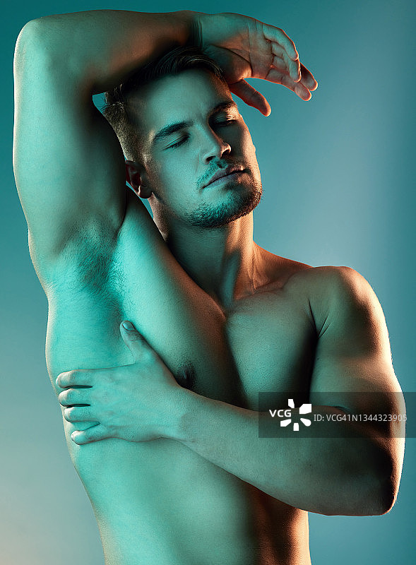 蓝色背景下的英俊年轻男人图片素材