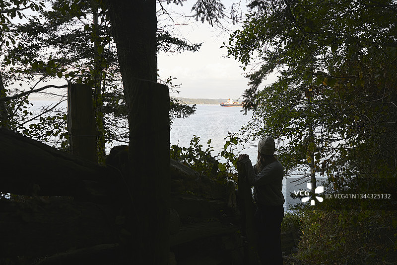 女人站在徒步小径旁，背景普吉特海湾图片素材