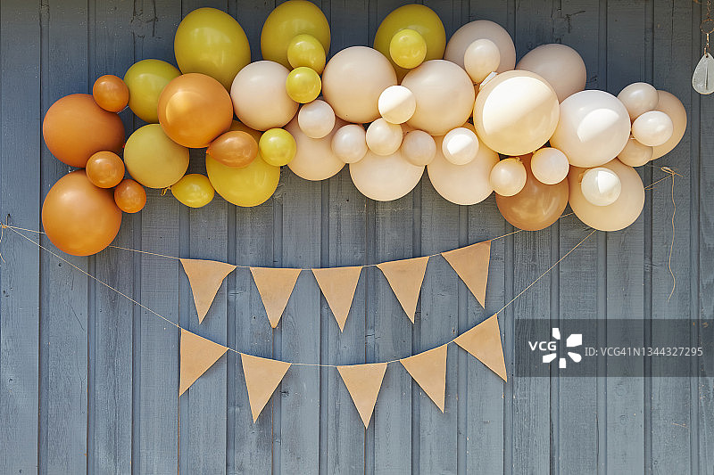 派对气球和毛毡banner悬挂在蓝色雪松壁板上图片素材