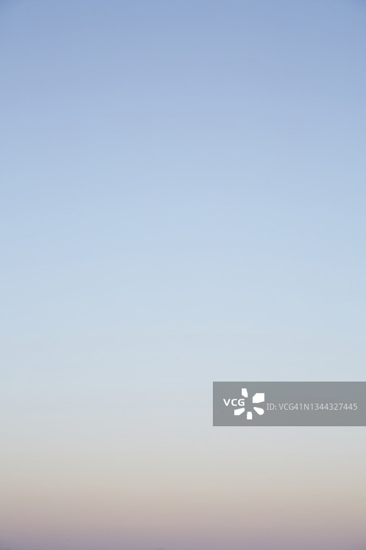 宁静舒缓的竖版抽象天空，渐变色从浅蓝色到日落橙色图片素材