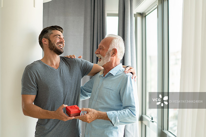 快乐的年轻人给父亲送生日礼物图片素材