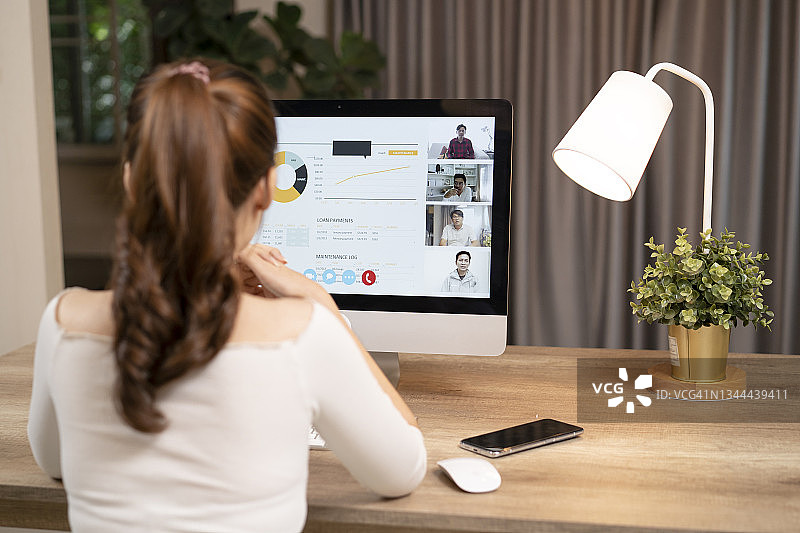 商务女性在家中坐在沙发上，在网上简报时进行视频通话并向笔记本电脑竖起大拇指图片素材