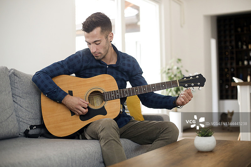 青年在给吉他调音图片素材