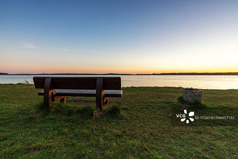 日落时湖边的长椅图片素材