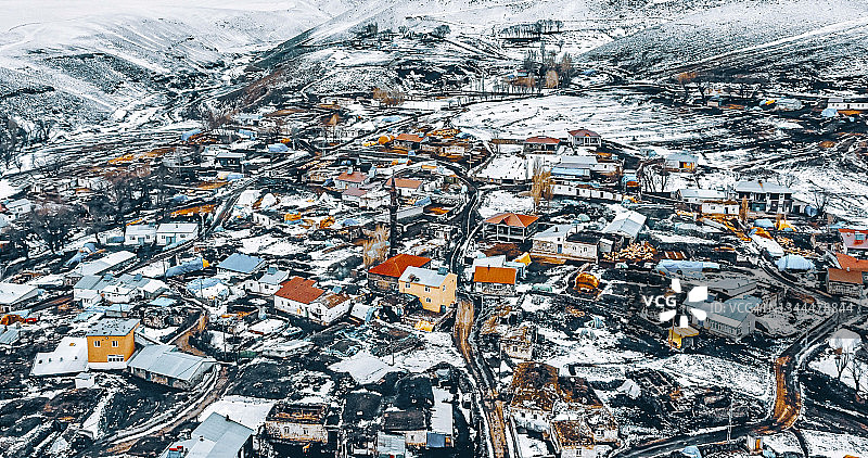 航拍：冬季白雪覆盖的小镇和山脉图片素材