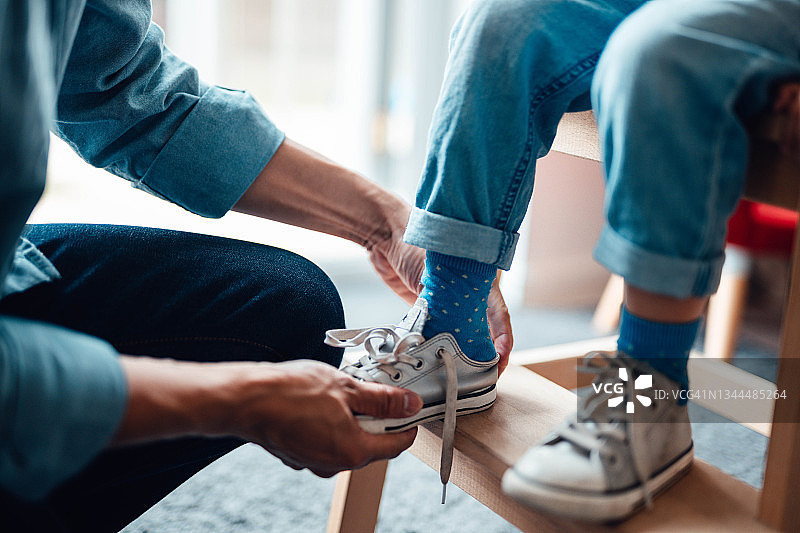 父亲帮助孩子穿鞋的特写镜头图片素材