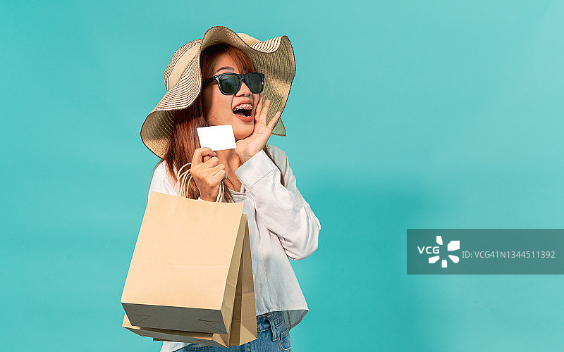 微笑的亚洲女性手持信用卡，数字支付图片素材