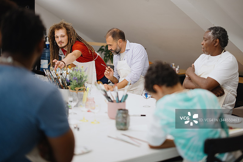 艺术课上人们在葡萄酒杯上绘画图片素材