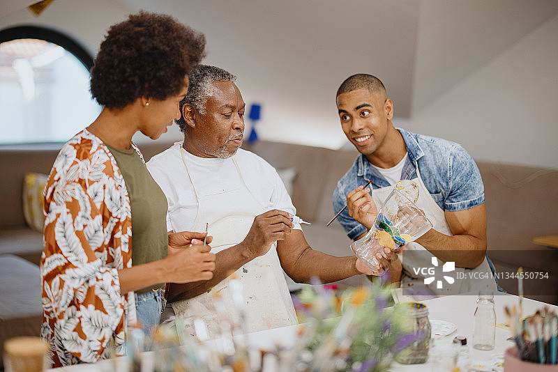 年长的父亲和年轻的成年儿子在工艺美术小组课上与美术老师交谈图片素材