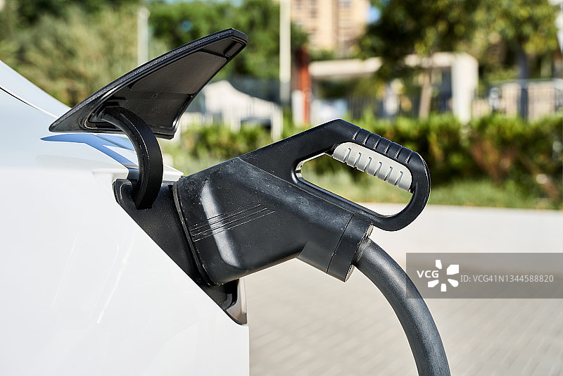 白色汽车插入充电线（环保概念）图片素材