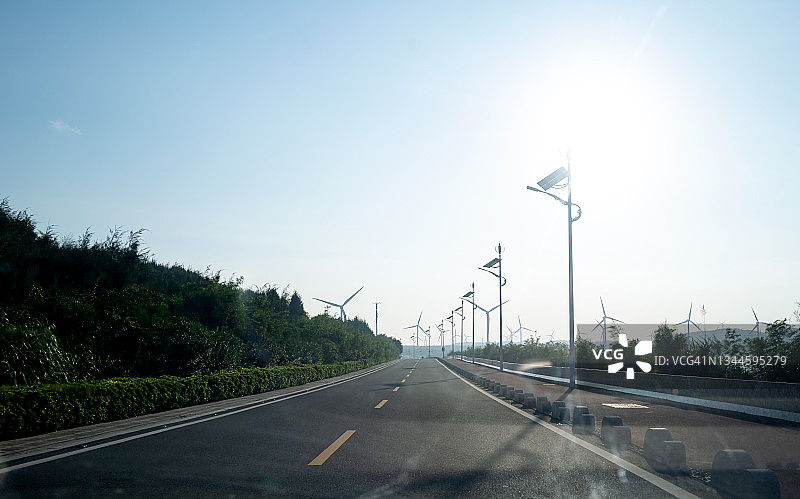 远处有风力涡轮机的沥青路图片素材