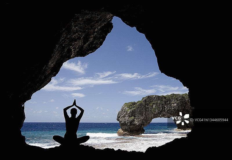 在洞穴中做瑜伽的年轻女人图片素材
