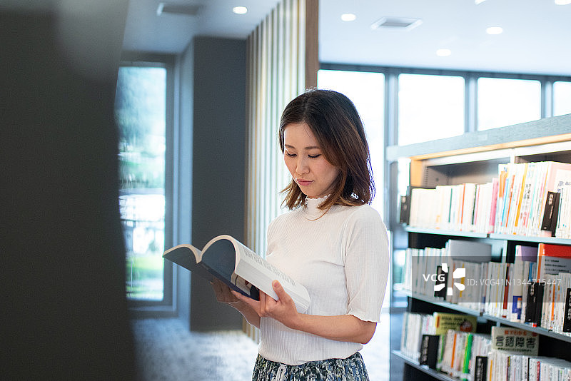 中年妇女在图书馆阅读图片素材