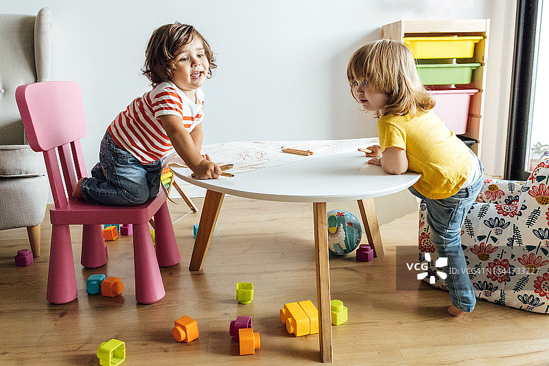 学龄前儿童在现代幼儿园游戏室的桌旁画画图片素材