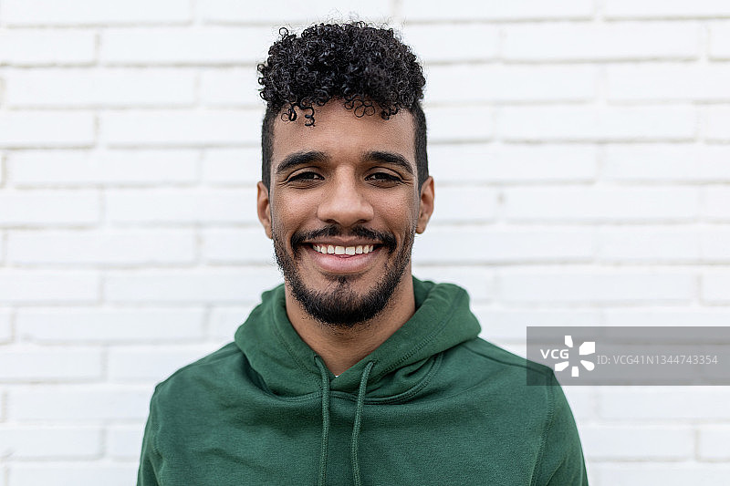 微笑的年轻男人站在白色背景前图片素材