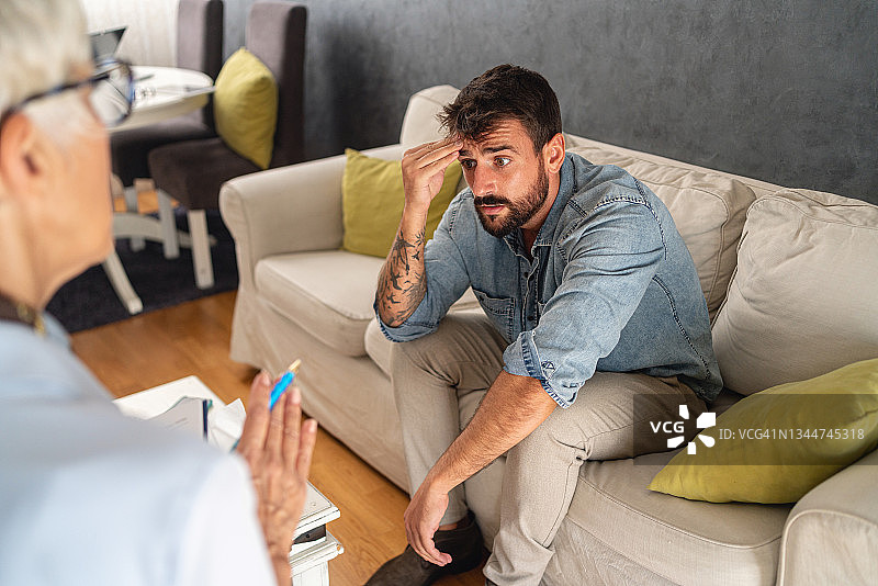 在治疗期间努力集中的沮丧年轻人图片素材