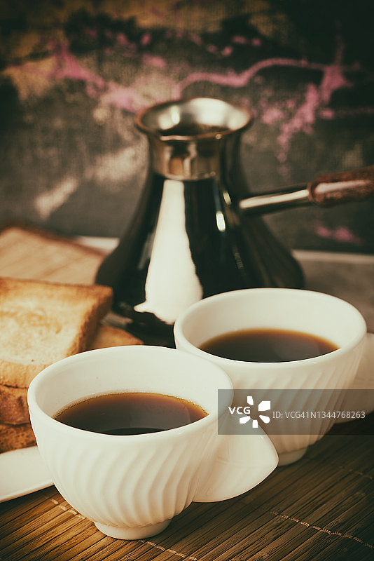 咖啡倒入白杯，烤面包，餐桌上的早餐图片素材