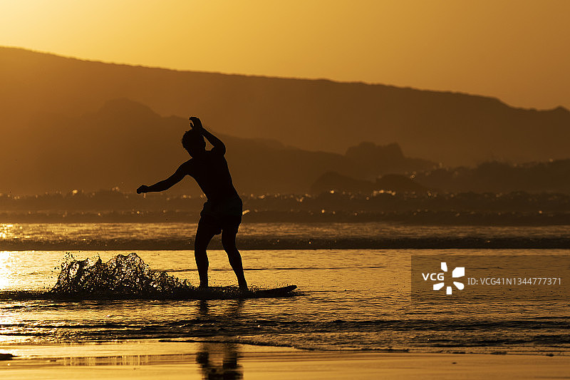 日落时分玩滑板的男孩图片素材