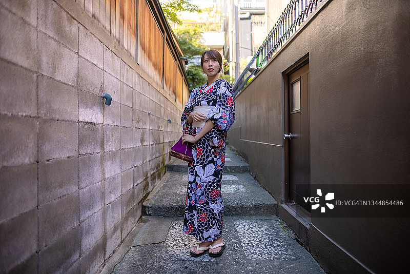 穿浴衣站在狭窄小路上的日本女人全身像图片素材