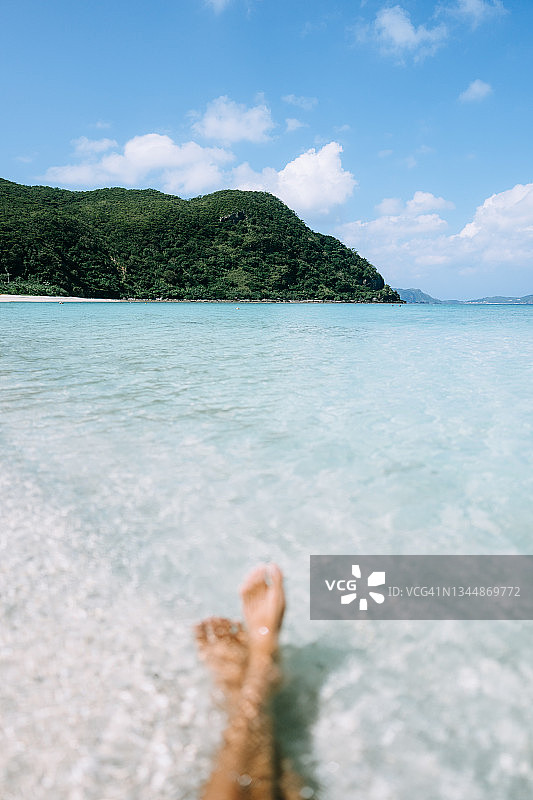 冲绳庆良间群岛热带海滩清澈海水中的赤脚图片素材