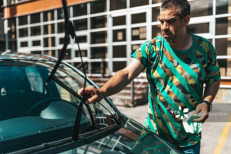 中年男人清洗汽车挡风玻璃图片素材