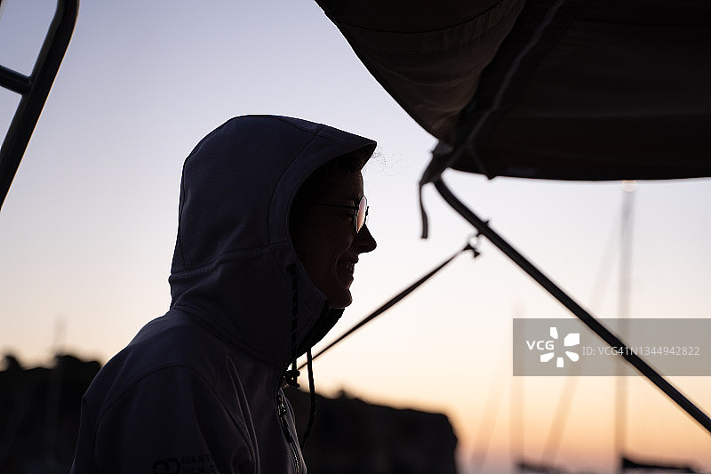 戴眼镜的女人在船上观赏海上日落图片素材