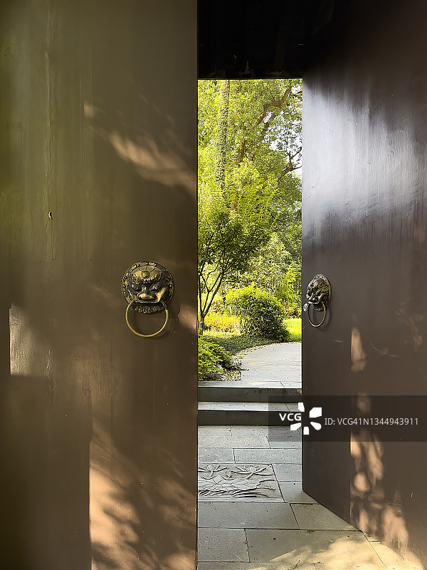 中式江南园林的半开大门显露出里面的绿色植物图片素材