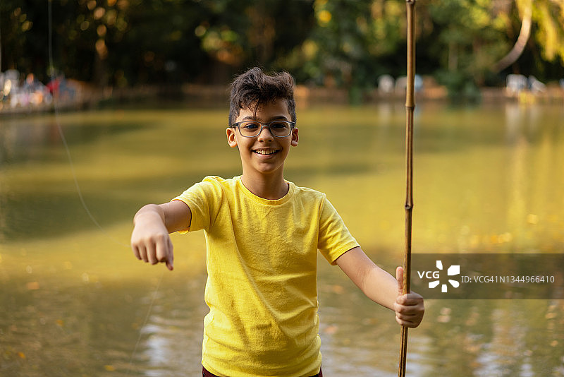 男孩拿着钓鱼竿和鱼钩图片素材