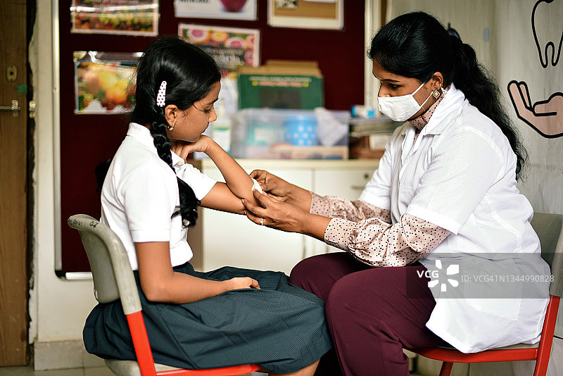 校医给女学生的胳膊贴创可贴图片素材