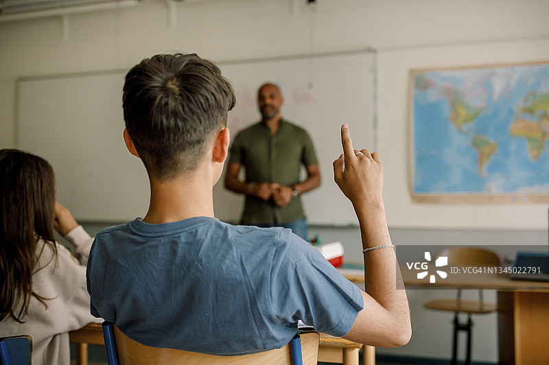 男教授在高中授课时，进行指点的青少年男学生图片素材