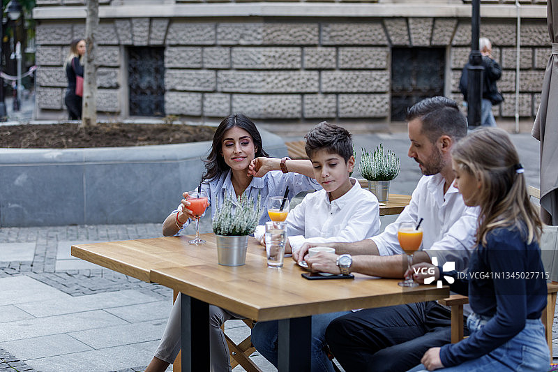 在城市街道餐厅里享受时光的快乐家庭图片素材