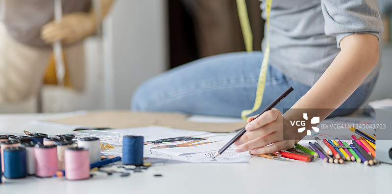 专业女时装设计师在工作室绘制服装设计草图图片素材