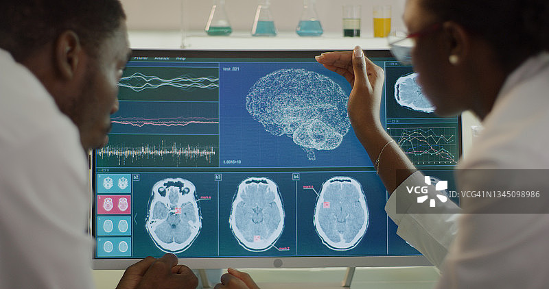 实验室设备与电脑脑电波研究屏幕上的非洲裔科学家讨论图片素材