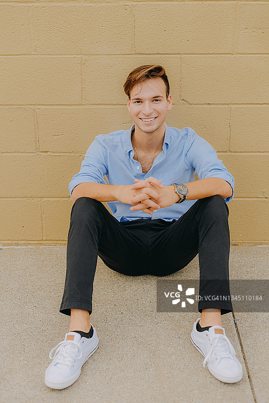 双手紧握坐在地上的漂亮少年图片素材