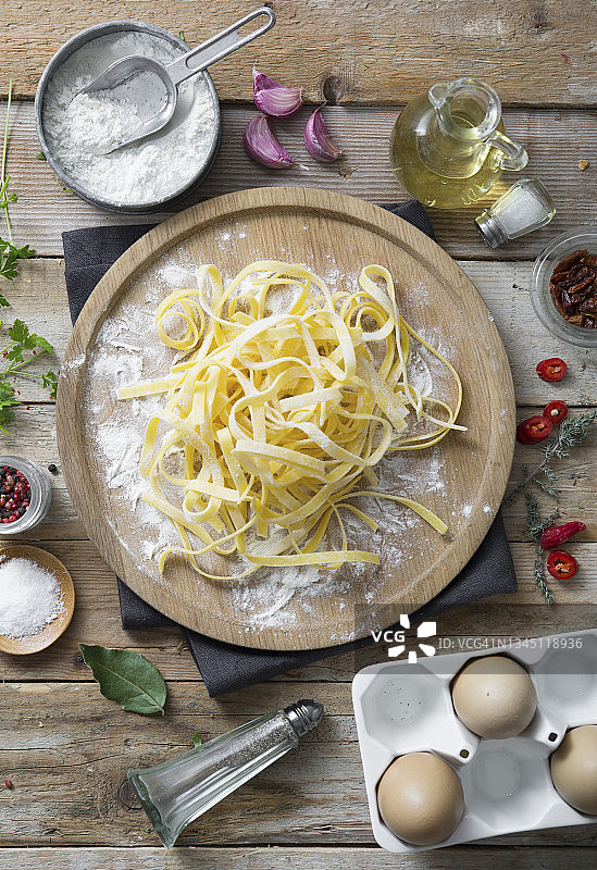 木盘上的新鲜未煮熟的意大利宽面条图片素材